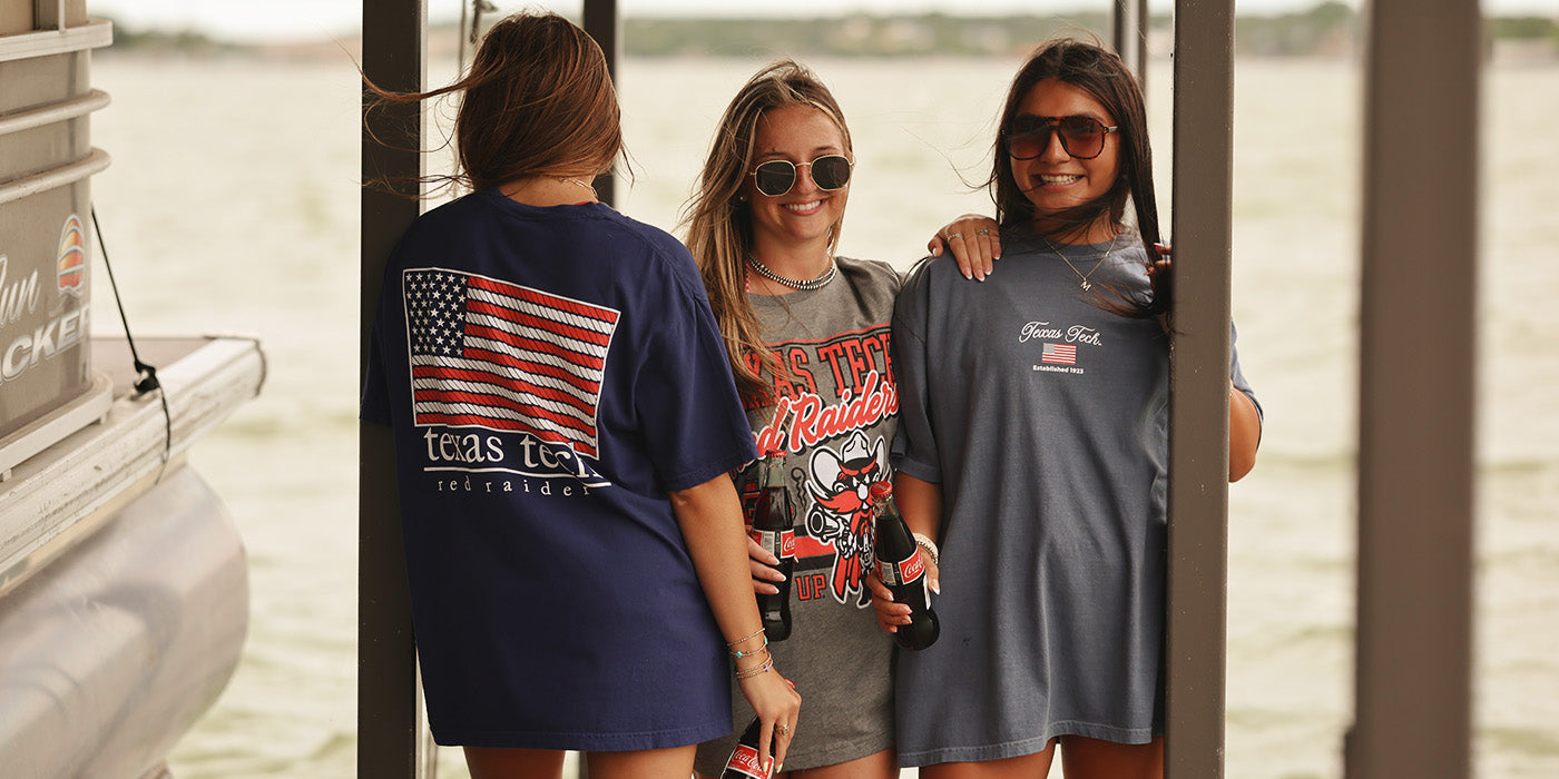Girls on dock at lake wearing patriotic TTU shirts