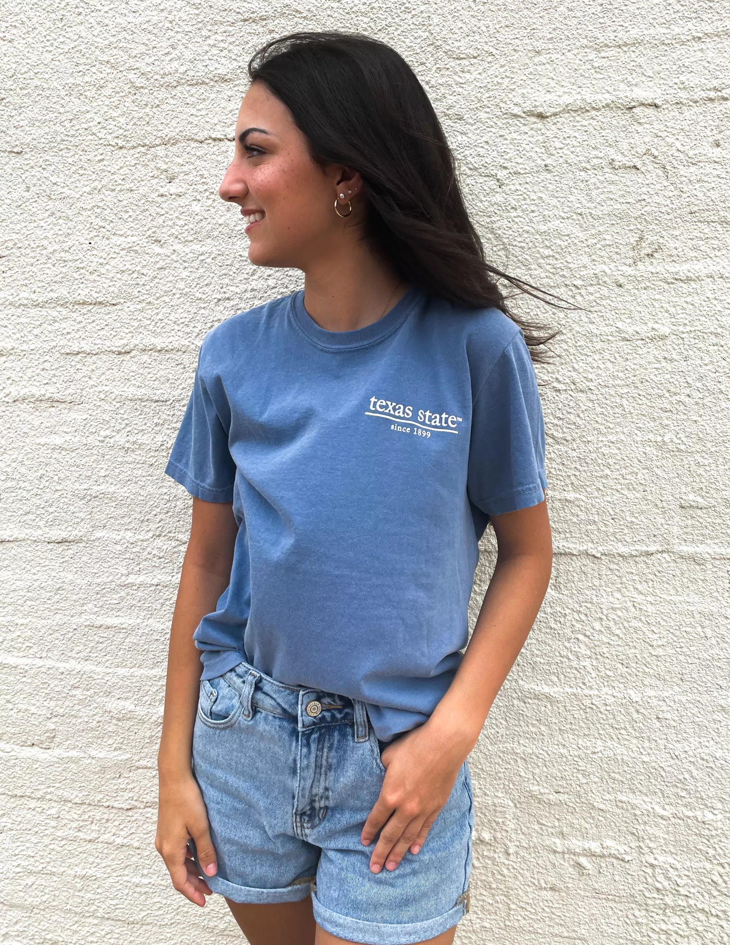 Texas State University student wearing blue TXST apparel outside.