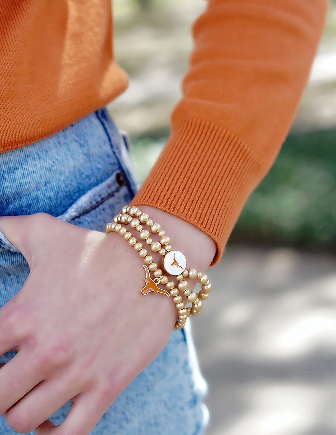 UT Longhorns student wearing a gold bracelet outside.