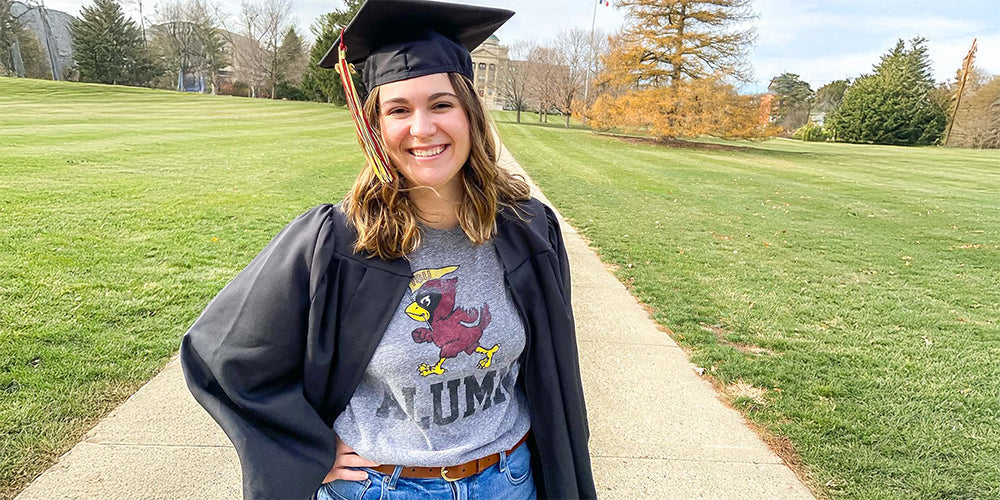 girl wearing an Iowa State alumni tshirt and a graduation cap and gown