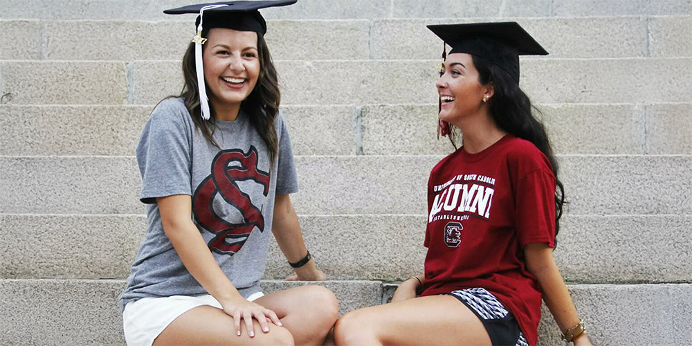 girls wearing USC alumni shirts with graduation caps on