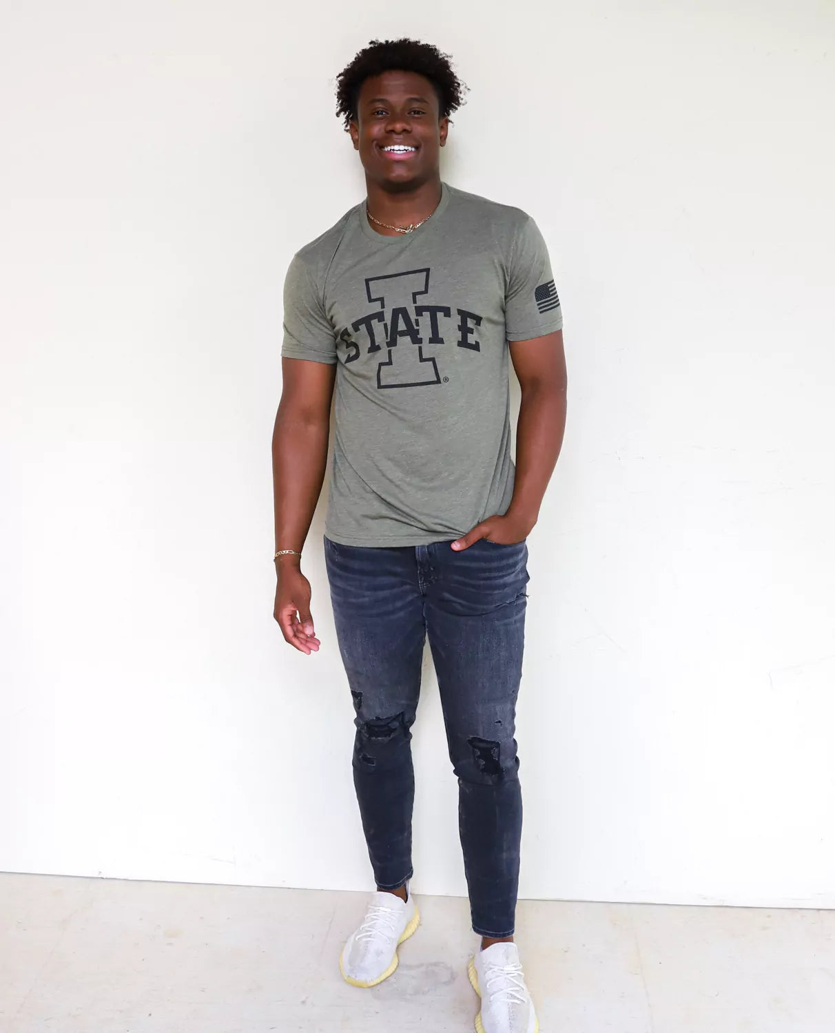 ISU Cyclones student wearing military green Iowa State University apparel against a white background. 