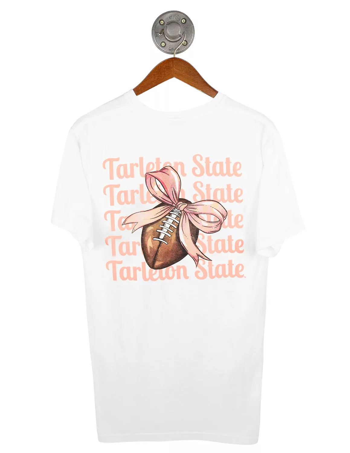White Tarleton State University unisex t-shirt featuring a stacked pink "Tarleton State" text as the background. In the center of the shirt is a graphic of a brown football with a pink bow tied around it. 