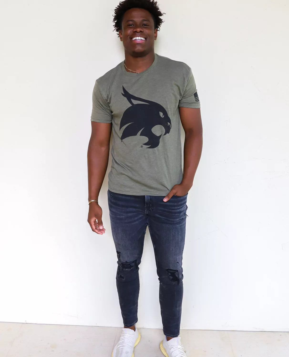 TXST Bobcats student wearing Texas State University apparel against a white background.