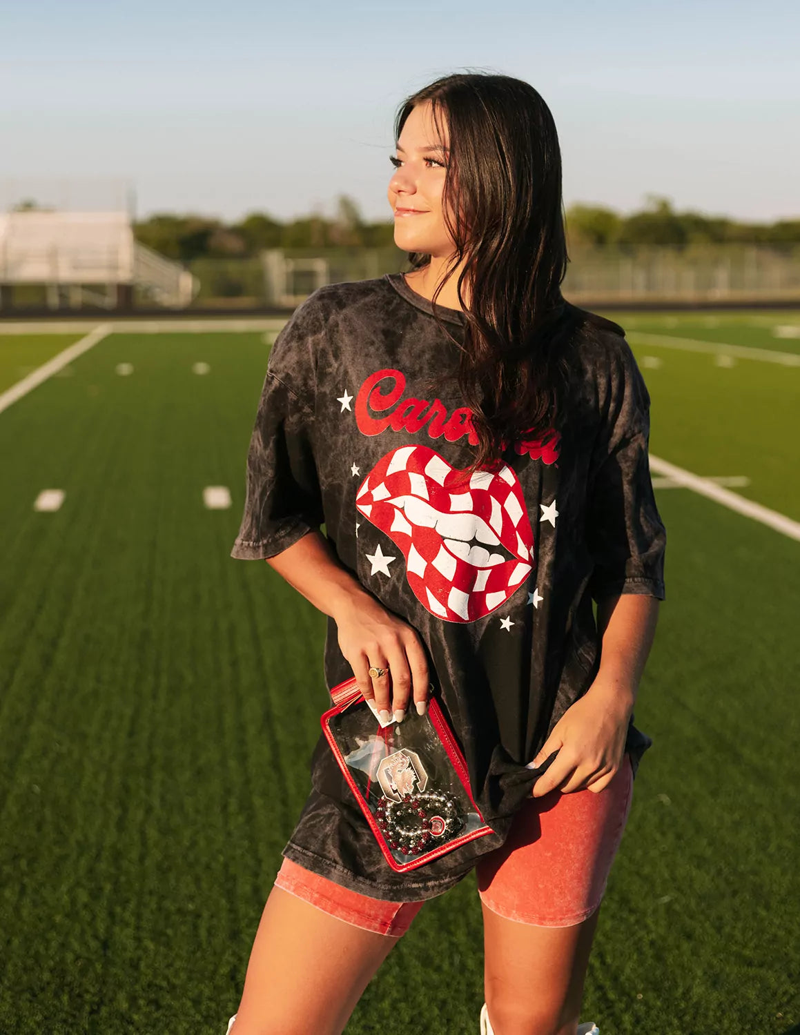 USC Gamecocks student wearing black tie-dye University of South Carolina apparel on a football field. 