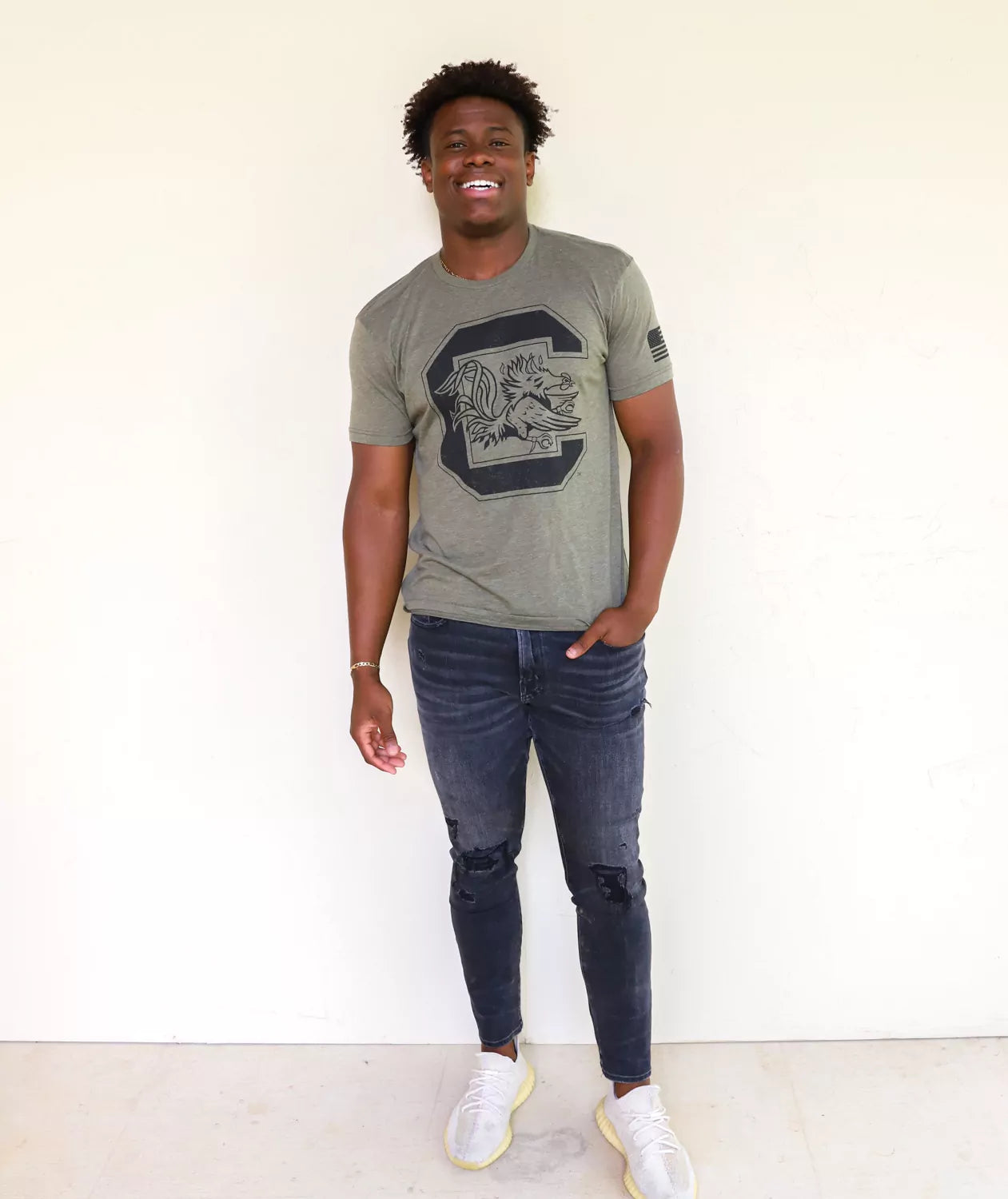 USC Gamecocks student wearing military green University of South Carolina apparel against a white background. 