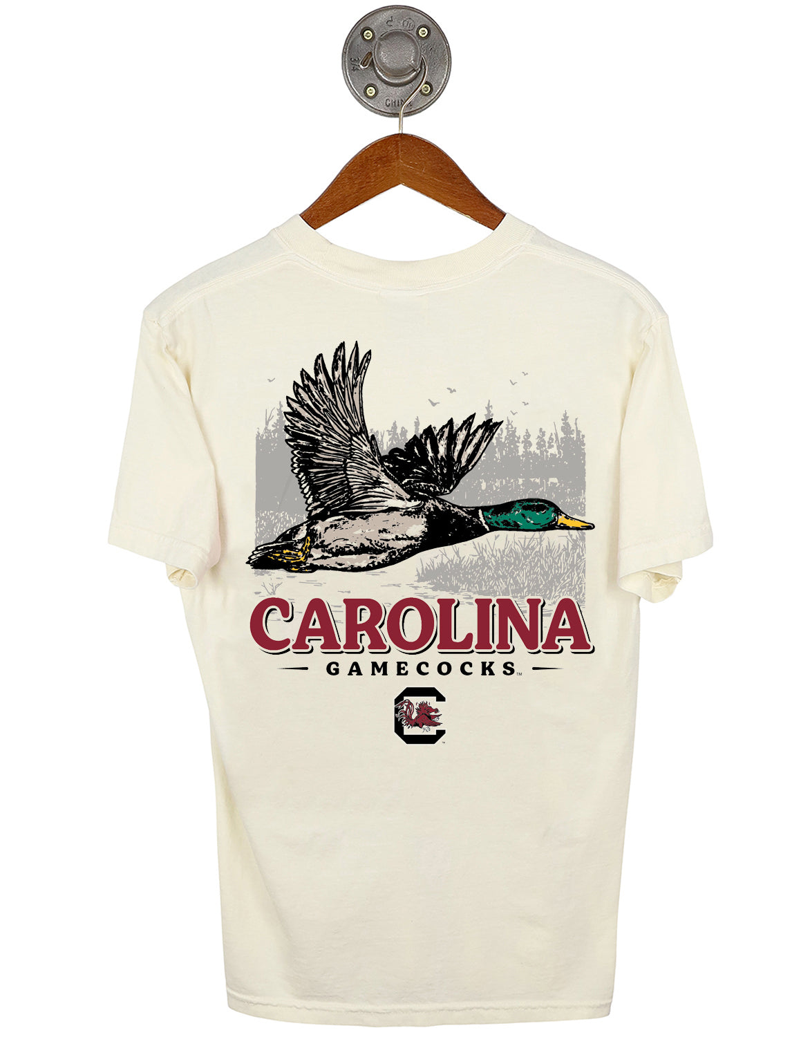 Back-view of ivory University of South Carolina unisex short-sleeve t-shirt that features a mallard duck flying against a marshy landscape graphic with garnet and black lettering underneath.
